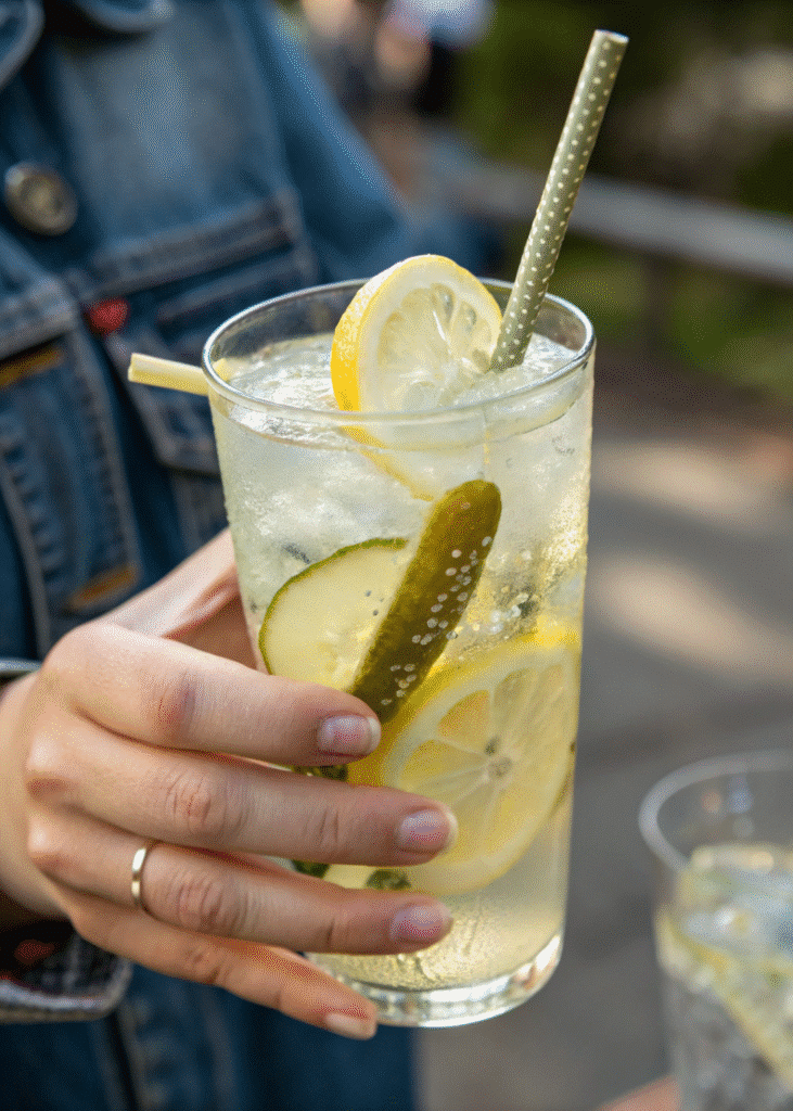 Glass of pickle lemonade with lemon and pickle slices